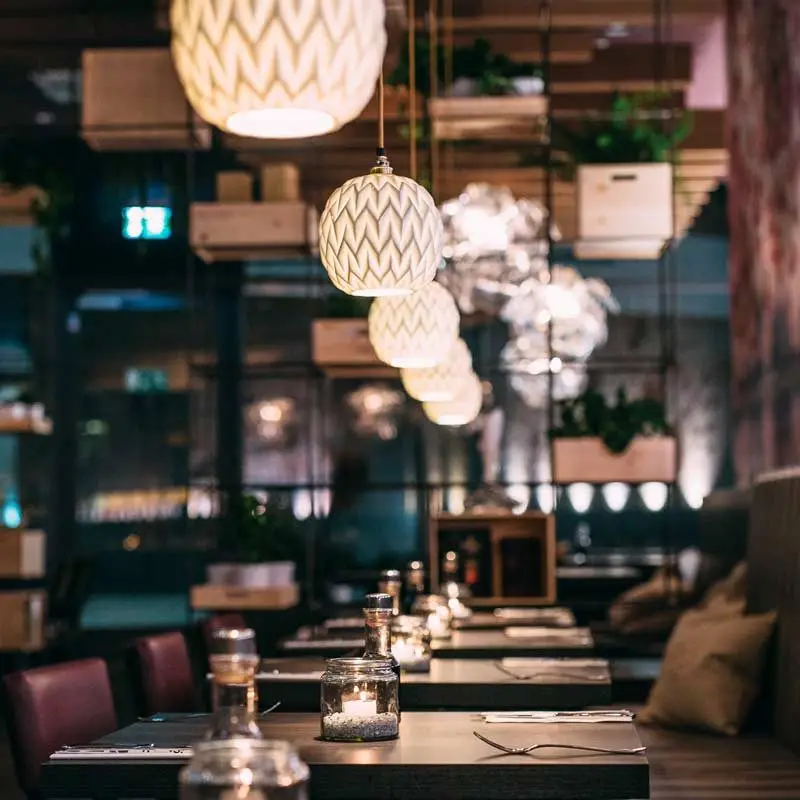 Lounge con banco, cojines y lámparas esféricas en el Mikôto Stuttgart
