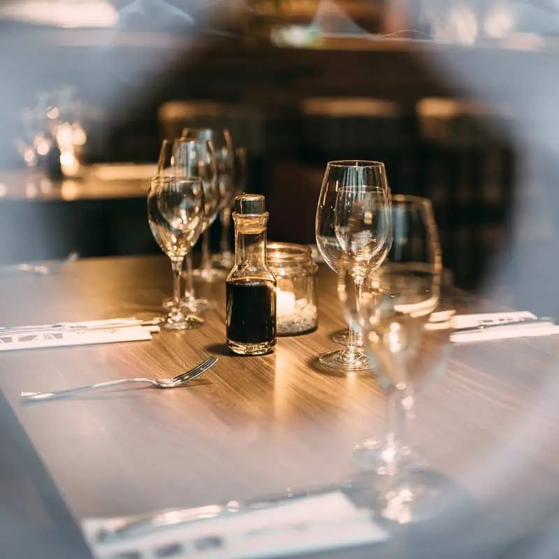 Mesa preparada con copas de vino y una vela en el Mikôto Stuttgart